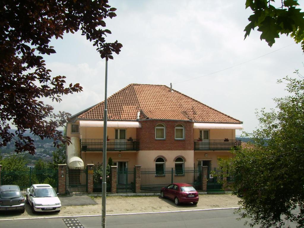 a house with cars parked in front of it at Villa Nevenka Rooms in Belgrade
