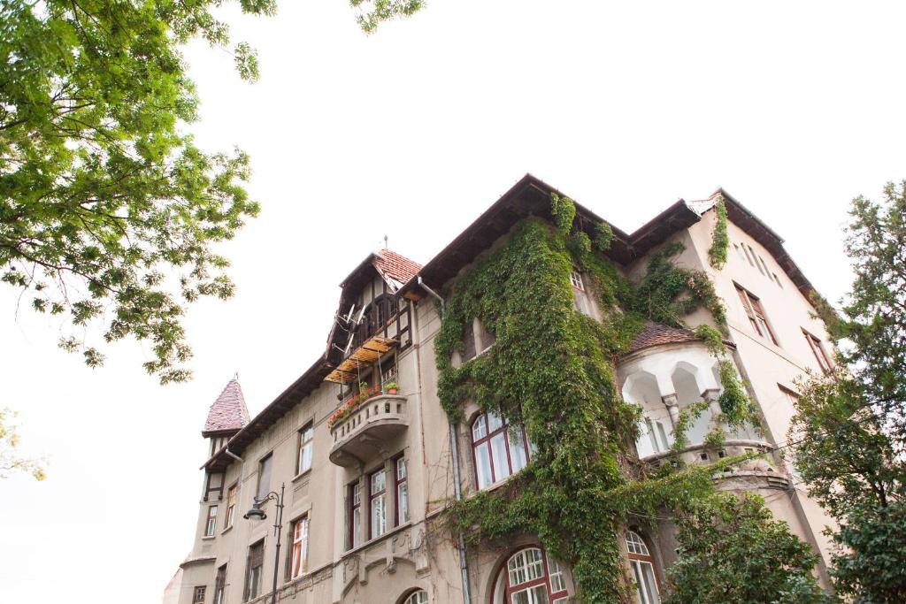 Un vieux bâtiment avec du lierre sur lui dans l'établissement Great Central Apartment, à Sibiu
