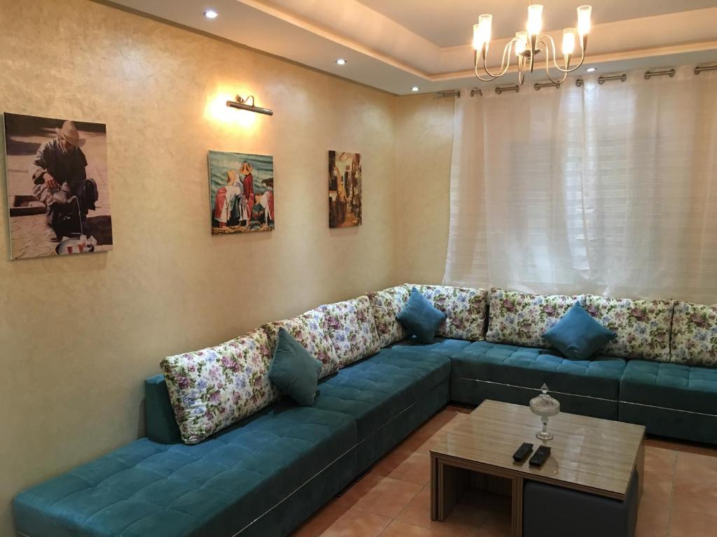 sala de estar con sofá azul y mesa en Résidence Bab Sebta, en Fnidek