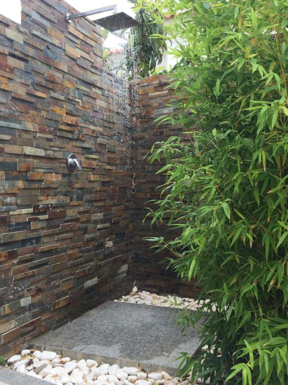 a brick wall with a water fountain at Casa de praia in Manta Rota