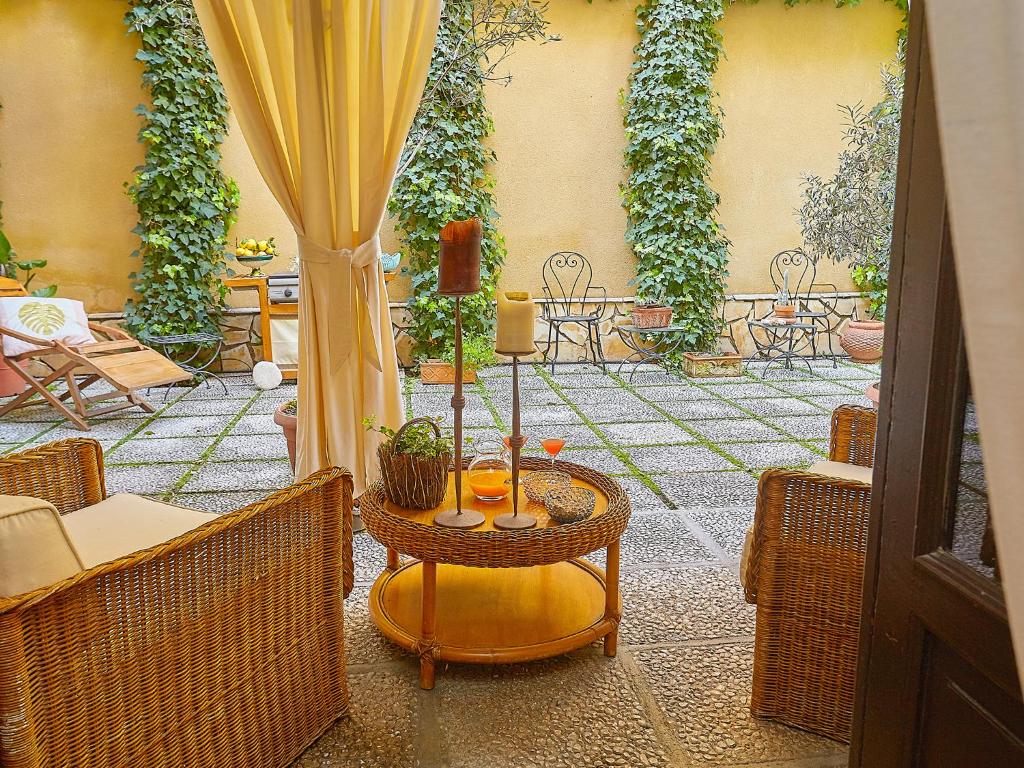 un patio al aire libre con mesa y sillas en Dimora dei Leoni - Dependance, en Palermo