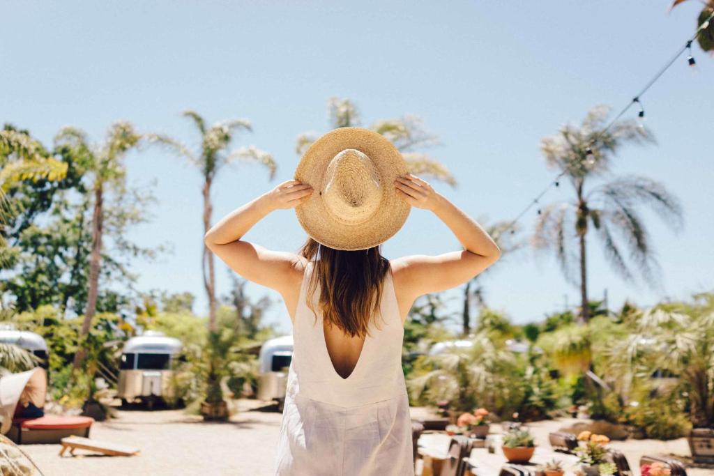 a woman wearing a straw hat standing at a resort at Caravan Outpost in Ojai