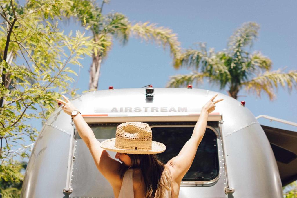 a woman in a hat sitting in the back of a van at Caravan Outpost in Ojai