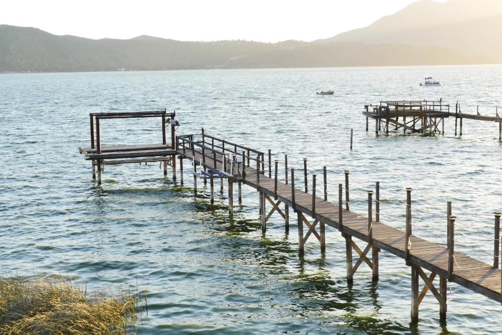 a pier in the water with mountains in the background at Bungalow on the lake in Clearlake