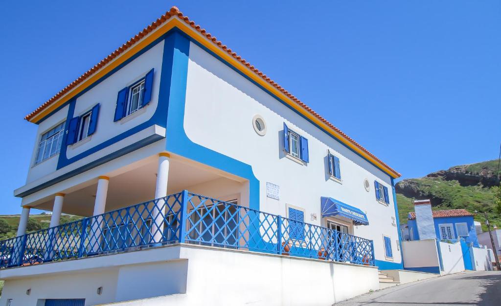 ein blau-weißes Gebäude mit einem Balkon in der Unterkunft Quarto Crescente in Nazaré