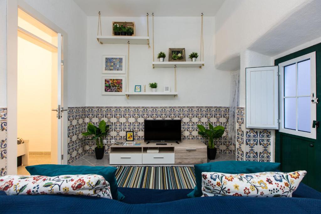 un salon avec un canapé bleu et une télévision dans l'établissement Santos Neighborhood Apartment, à Lisbonne