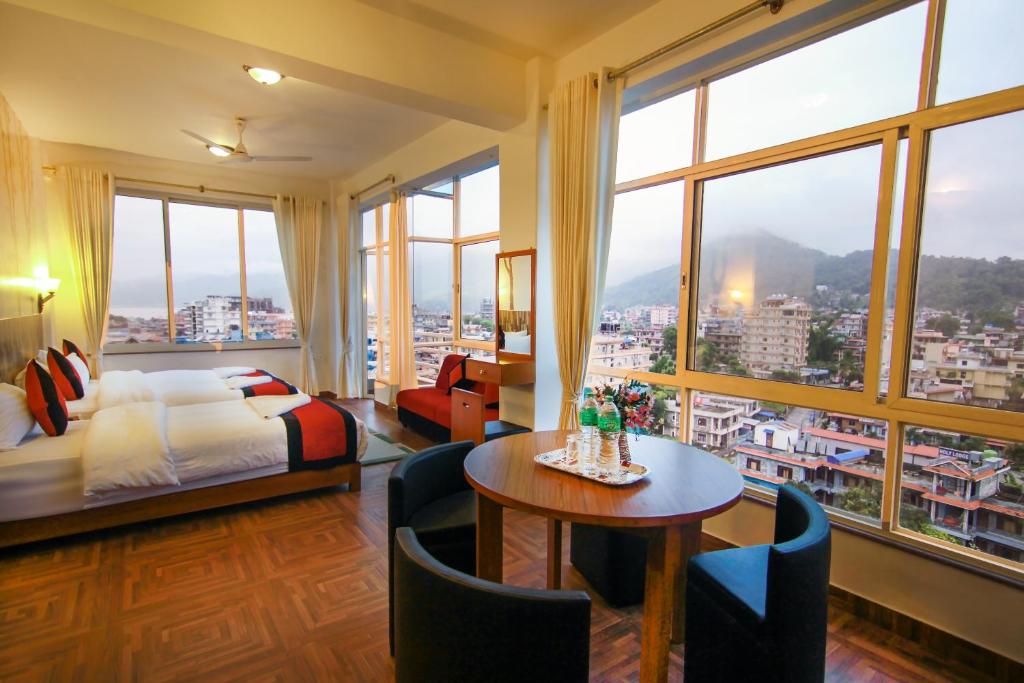 una camera d'albergo con un letto e un tavolo di Hotel City Inn - Mountain View a Pokhara