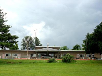 un gran edificio con un campo verde delante de él en Pleasant Stay Motel, en Ancaster