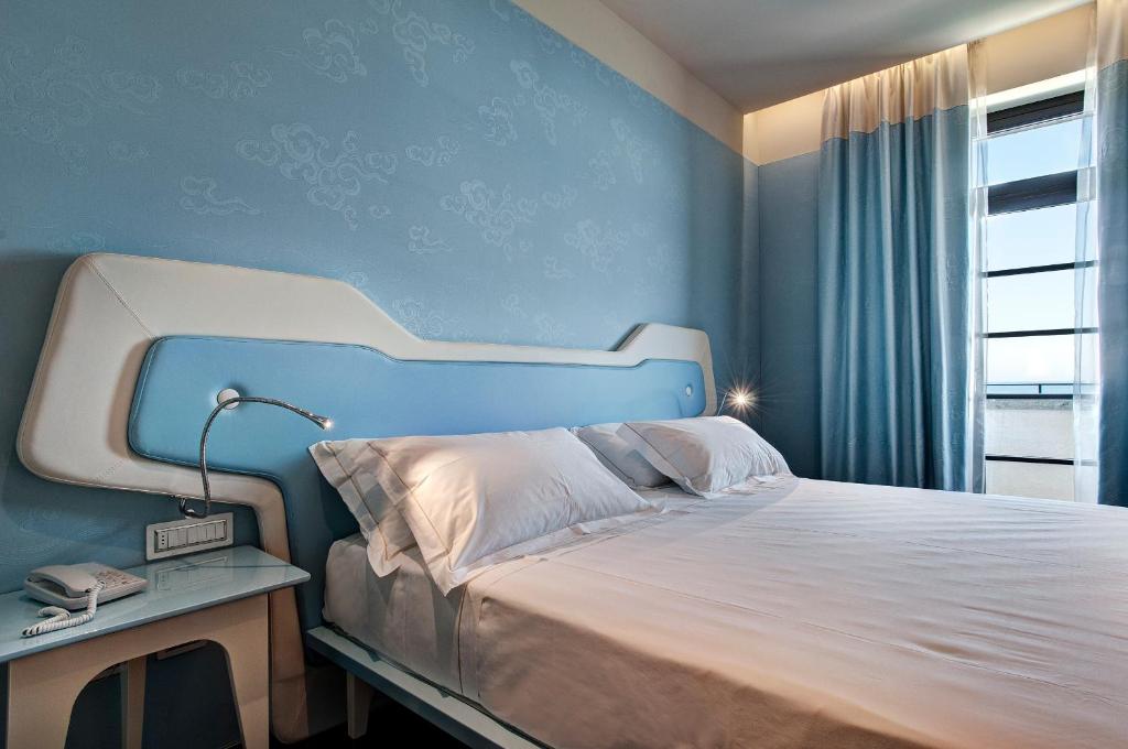 a bedroom with a bed with a blue wall at JR Hotels Bari Grande Albergo delle Nazioni in Bari