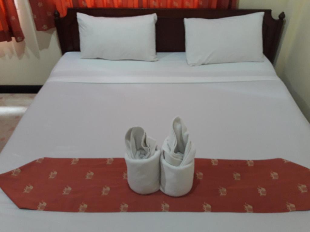 a bed with two pairs of shoes sitting on it at Southern Fried Rice in Kata Beach