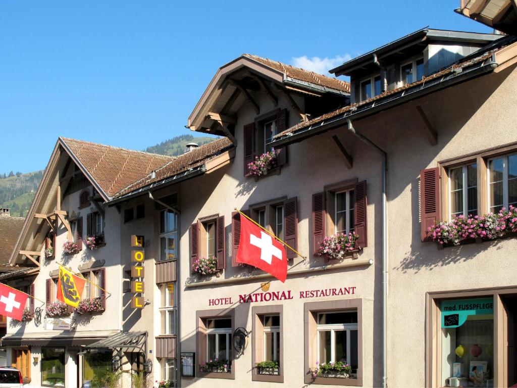 a building with a canadian flag on the side of it at Hotel National in Frutigen