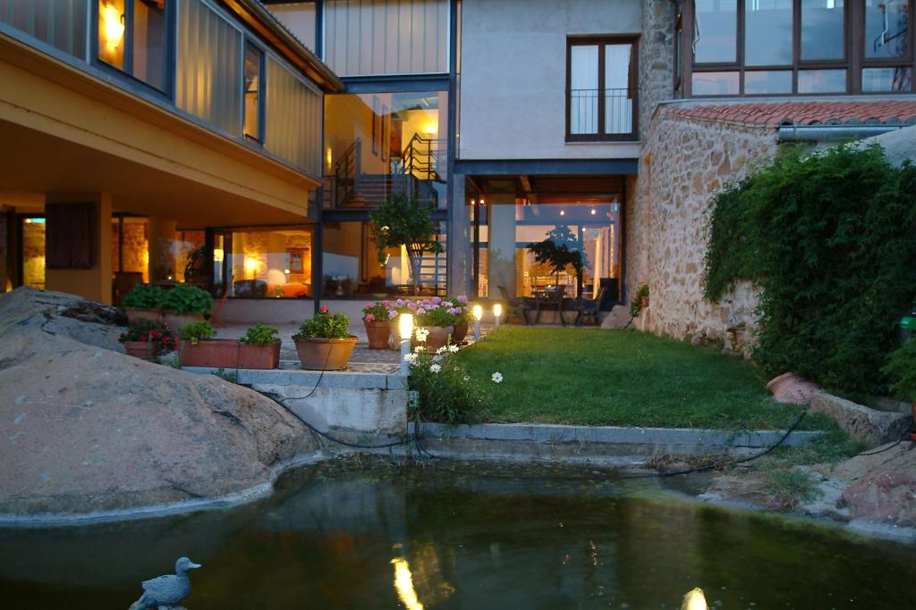 uma casa com um lago no quintal em El Turcal em Torremenga