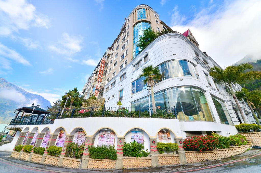 un gran edificio blanco con plantas delante en Dongpo Ti Lun Hotel, en Xinyi