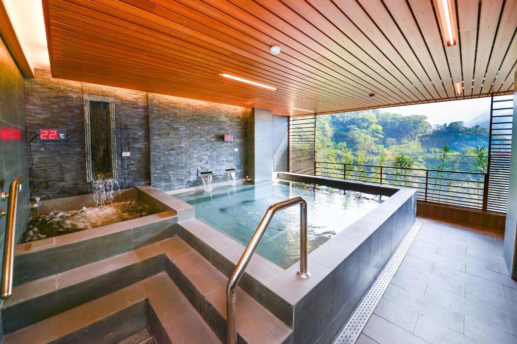 a bathroom with a bath tub with a large window at Dongpo Ti Lun Hotel in Xinyi