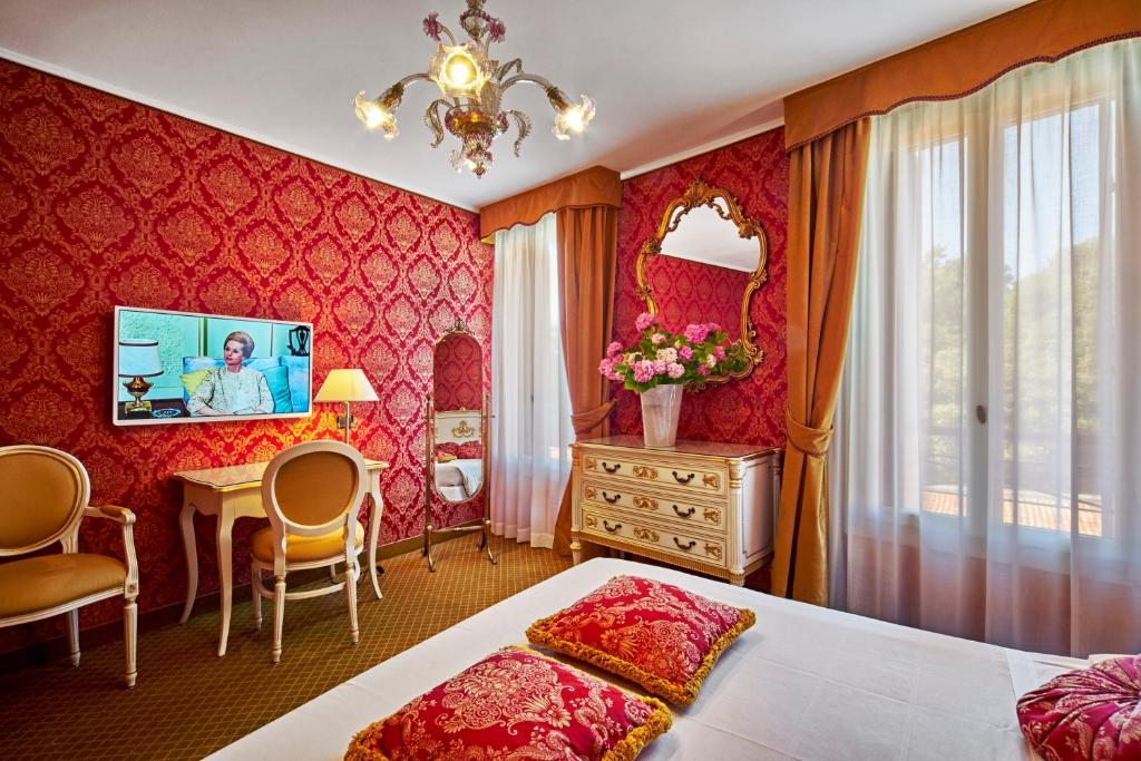 a hotel room with a bed and a desk and a table at Hotel Gardena in Venice