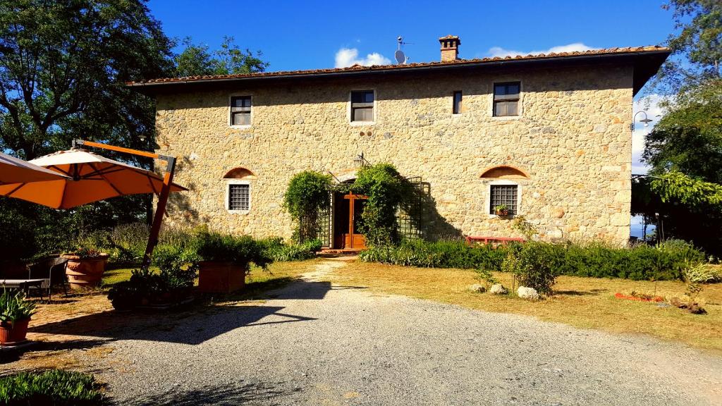 Cette grande maison en pierre est dotée d'une porte rouge. dans l'établissement Il Palagione, à San Gimignano