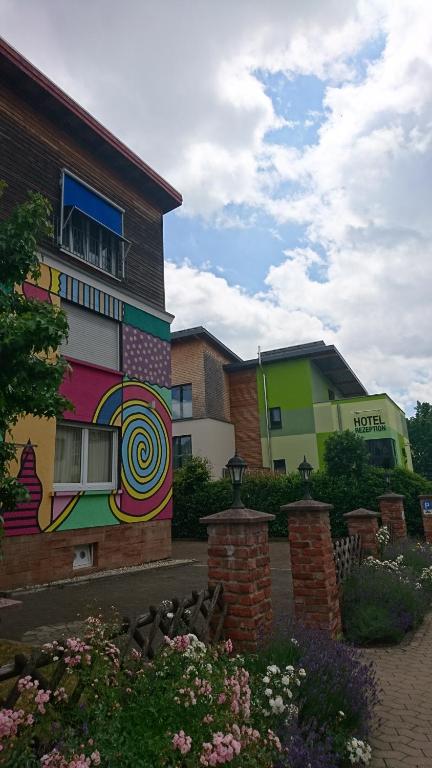 ein Gebäude mit einem bunten Wandbild an der Seite in der Unterkunft Hotel & Auberge le Journal in Sankt Wendel