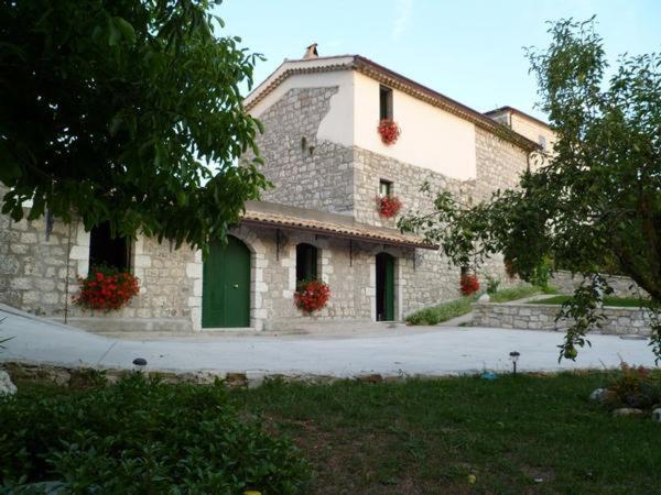 une maison en pierre avec une porte verte et une allée. dans l'établissement Affittacamere La Casella, à Gallo