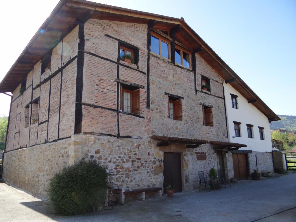 un gran edificio de ladrillo con ventanas. en Agroturismo Ondarre, en Segura