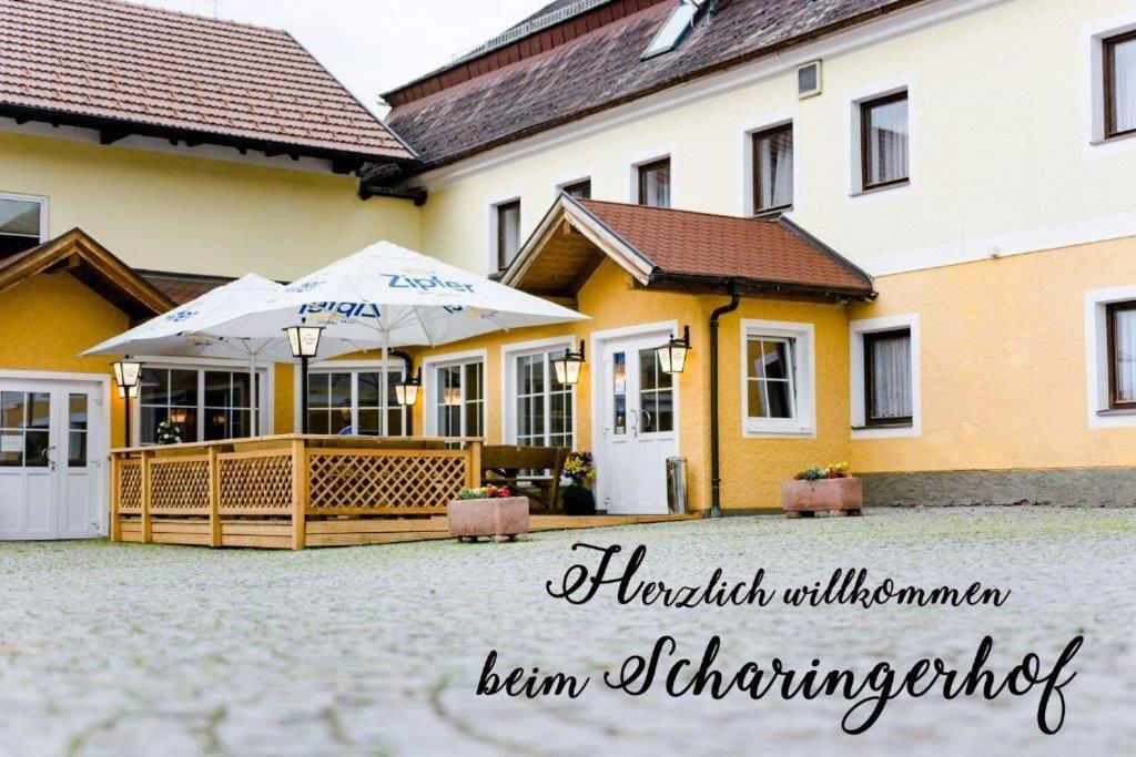 ein gelbes Gebäude mit einem Regenschirm davor in der Unterkunft Frühstückspension Scharinger Hof in Gilgenberg am Weilhart