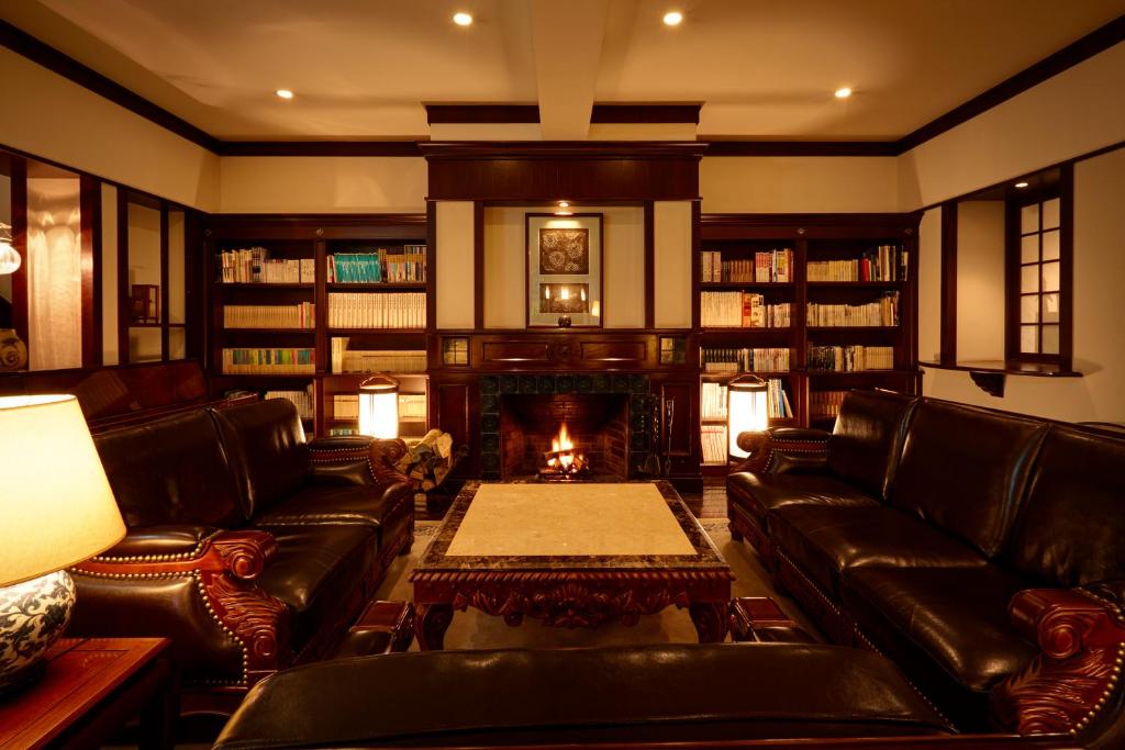 a living room with leather couches and a fireplace at Hamilton Ureshino in Ureshino