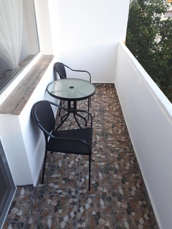 a small patio with two chairs and a table at Apartament Faleza Dunării in Orşova