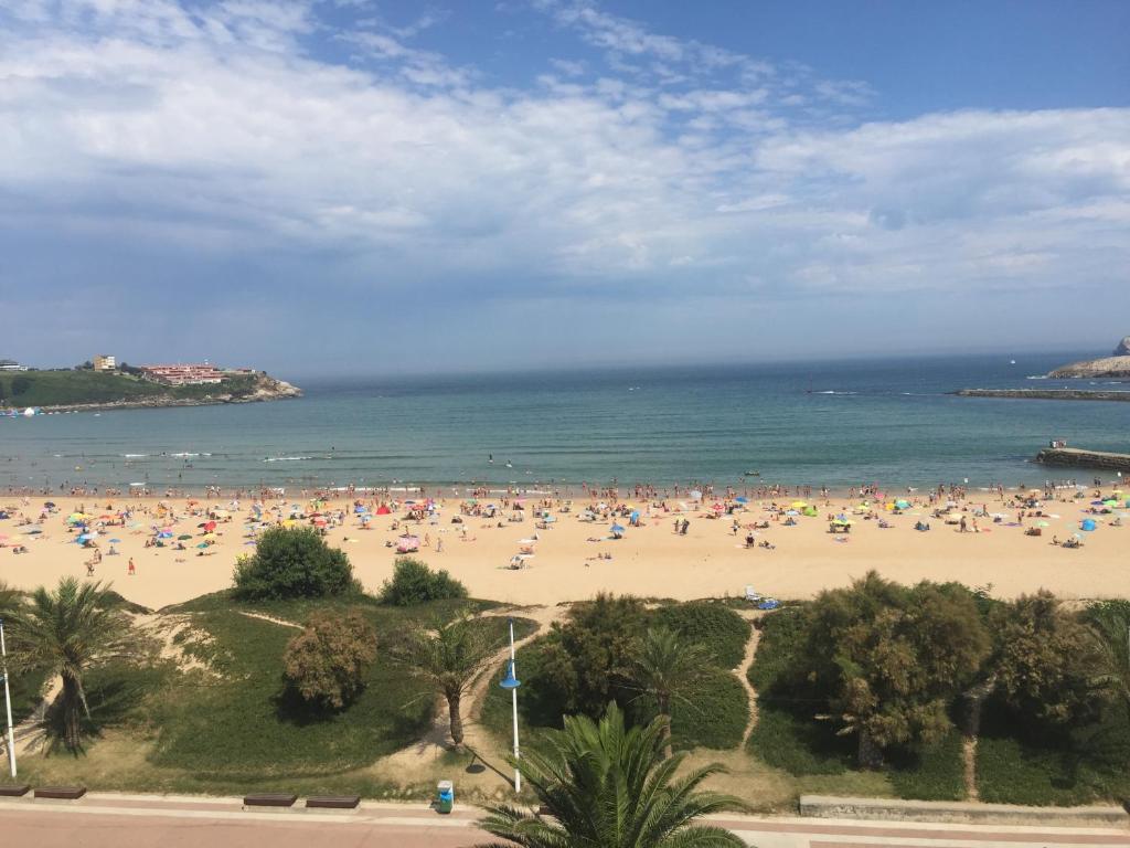 una playa con mucha gente en ella en Hotel la Concha de Suances, en Suances