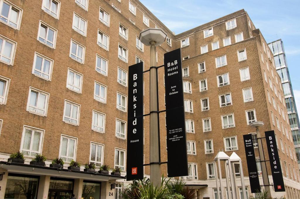 un gran edificio de ladrillo con señales delante en LSE Bankside House, en Londres