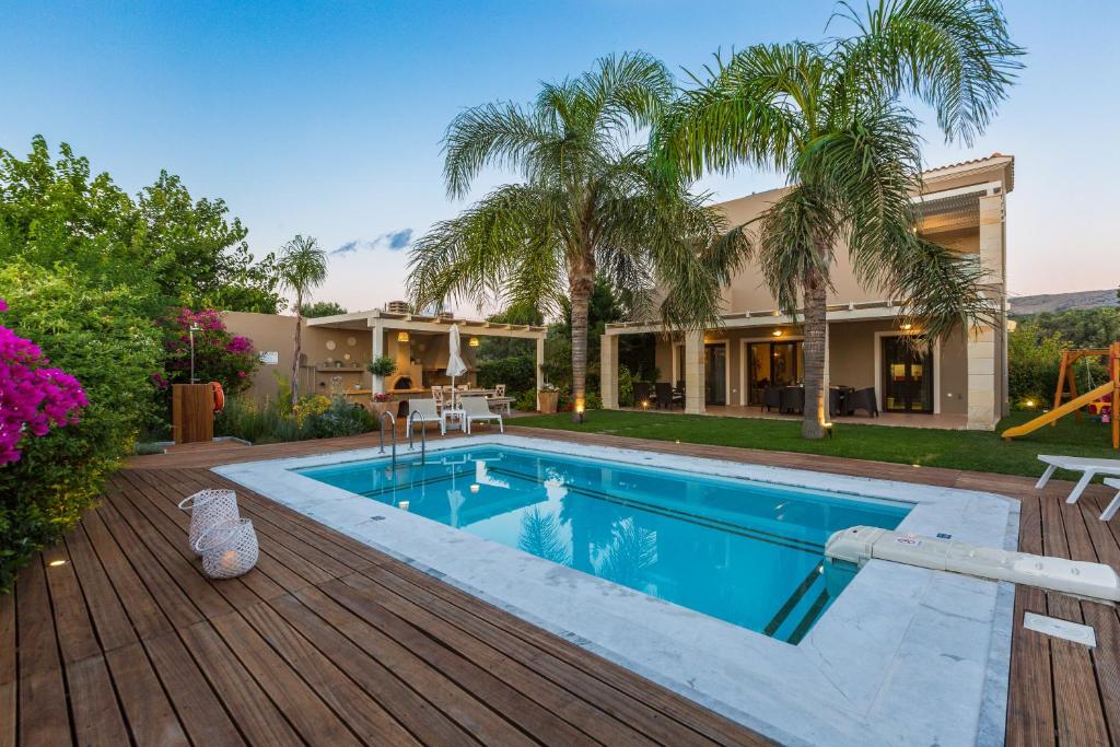 una casa con piscina en una terraza de madera en Aria Villas, modern paradise, By ThinkVilla, en Pigi