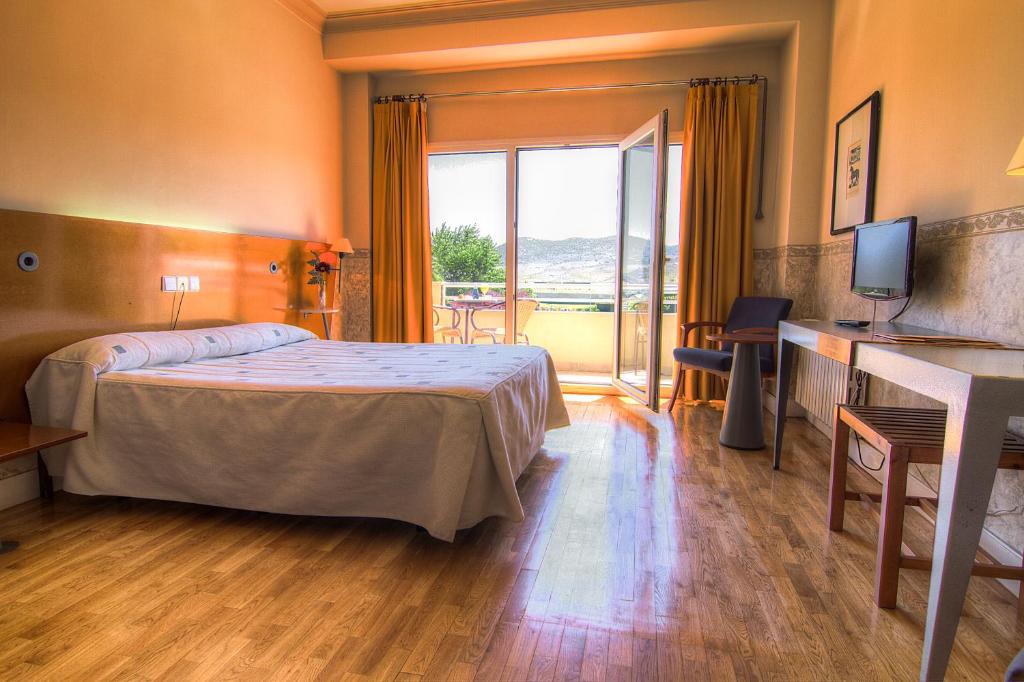 プラセンシアにあるHotel Azarのベッドと大きな窓が備わるホテルルームです。