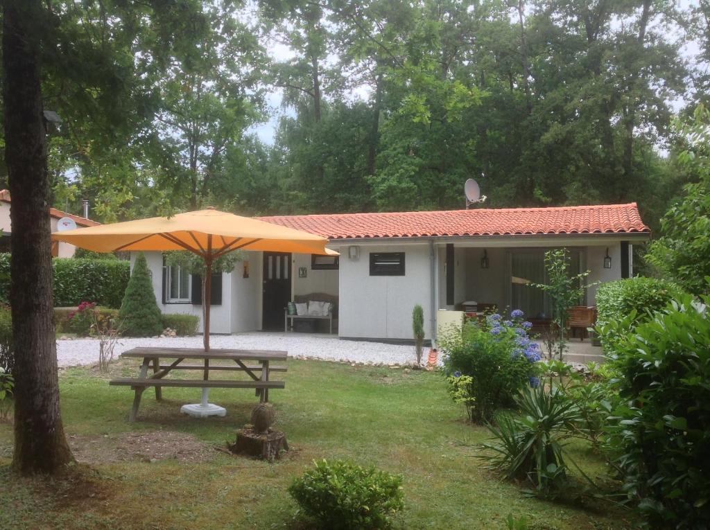 ÉcurasにあるVillage Le Chatのピクニックテーブルと傘付きの家