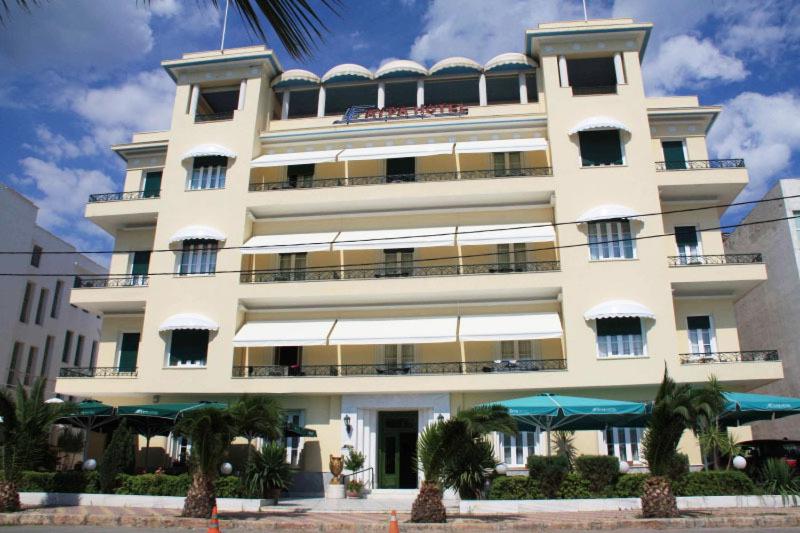 ein großes weißes Gebäude mit Palmen davor in der Unterkunft Avra Spa Hotel in Loutra Edipsou