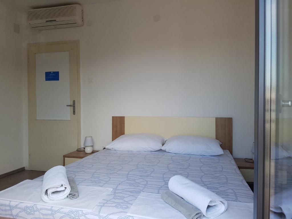 a bedroom with a bed with towels on it at Guest House Sombrero in Senj