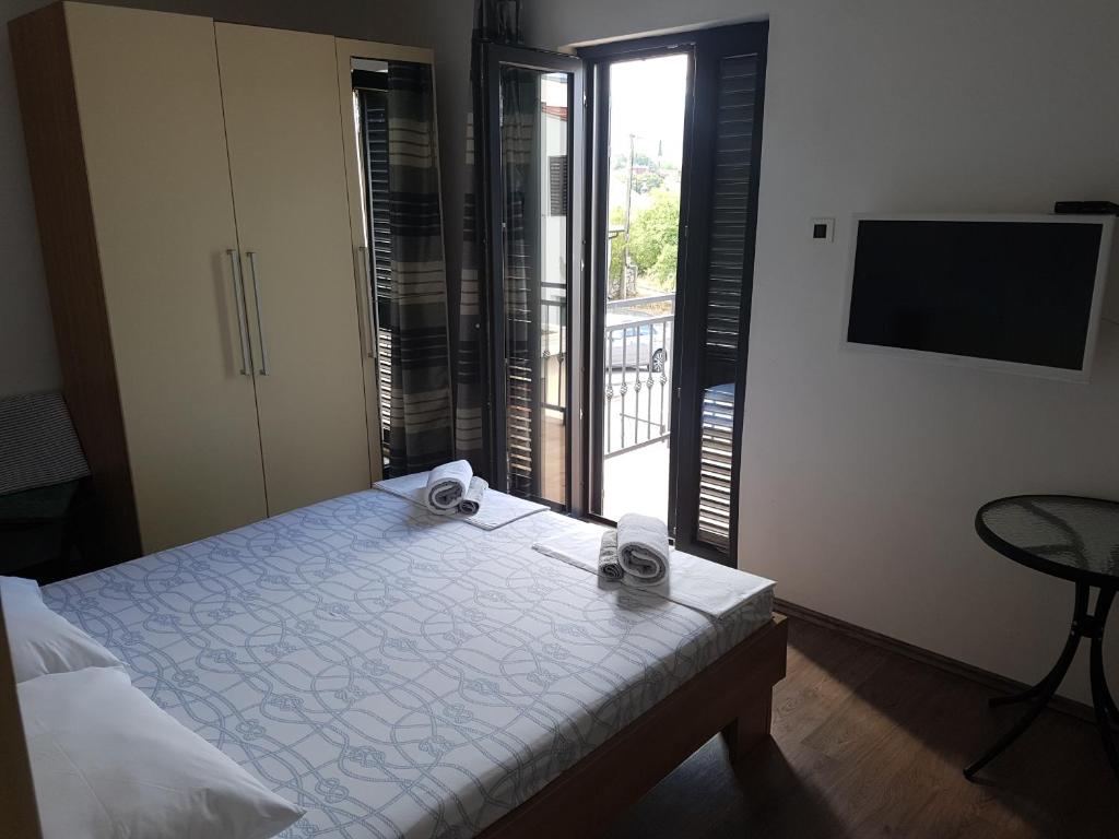 a bedroom with a bed and a balcony with a television at Guest House Sombrero in Senj