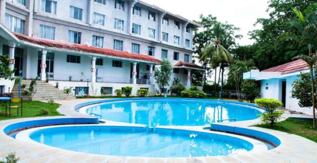 a large swimming pool in front of a building at Ramee Guestline Tirupati in Tirupati
