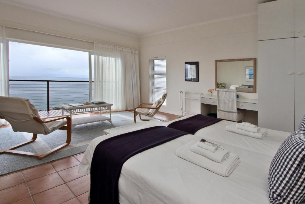 a bedroom with a large bed with a view of the ocean at Avian Leisure in Simonʼs Town
