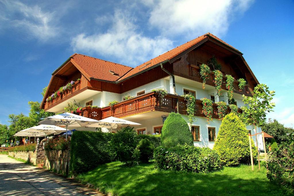 um grande edifício com plantas ao lado em Landgasthof Spitzerwirt em Sankt Georgen im Attergau