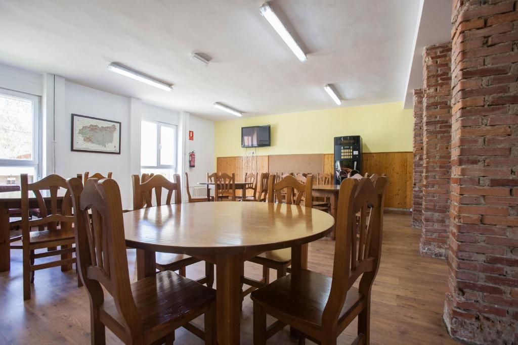 a dining room with a wooden table and chairs at Albergue de Sabero in Sabero