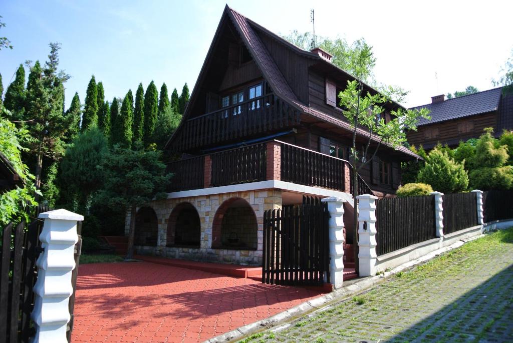 uma casa com uma cerca em frente em Domek letniskowy Grodek em Gródek Nad Dunajcem
