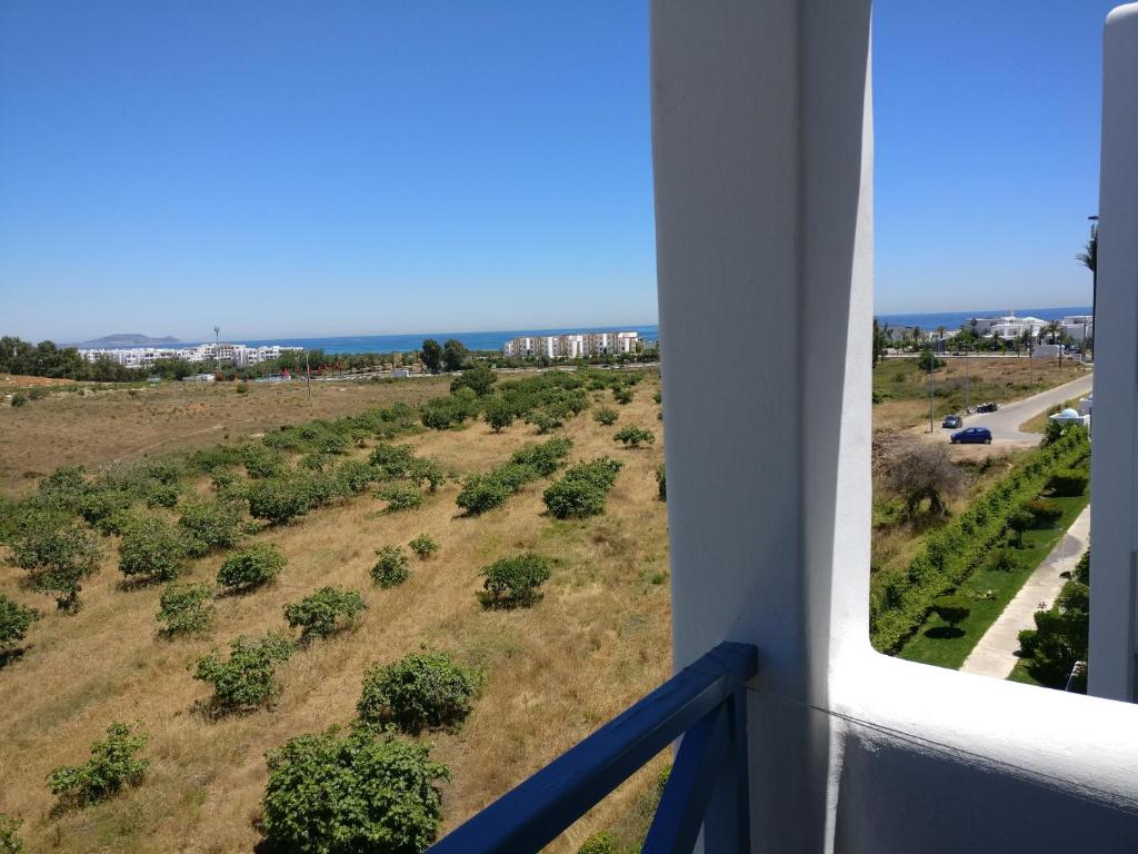 een balkon met uitzicht op een veld met bomen bij Jawhara Smir Marina Smir in Marina Smir