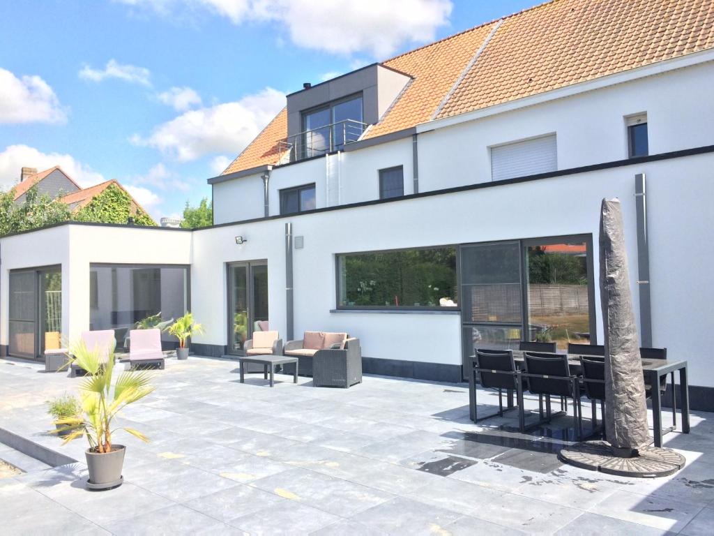a large white house with a patio at B&B Intermezzo in Middelkerke