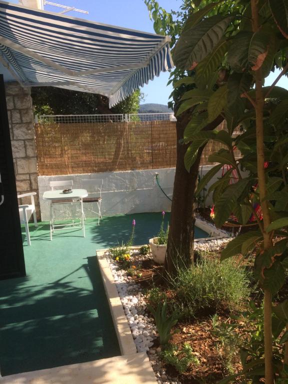 a backyard with a pool and a table and a tree at Apartment Nada in Ston