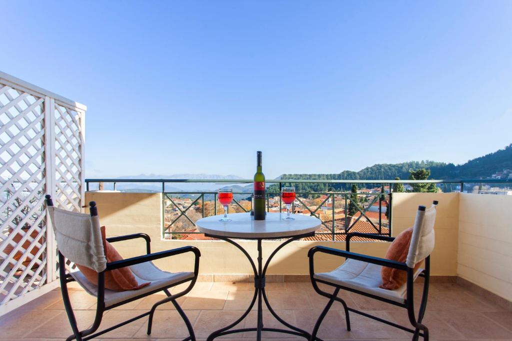 a table with two chairs and a glass of wine on a balcony at Iremia in Kariá