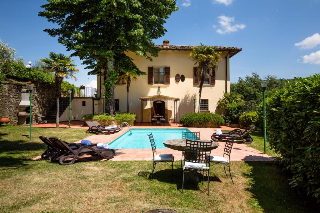a house with a pool and a table and chairs at Casa Vacanze Villa il Castellaccio in Lucolena in Chianti