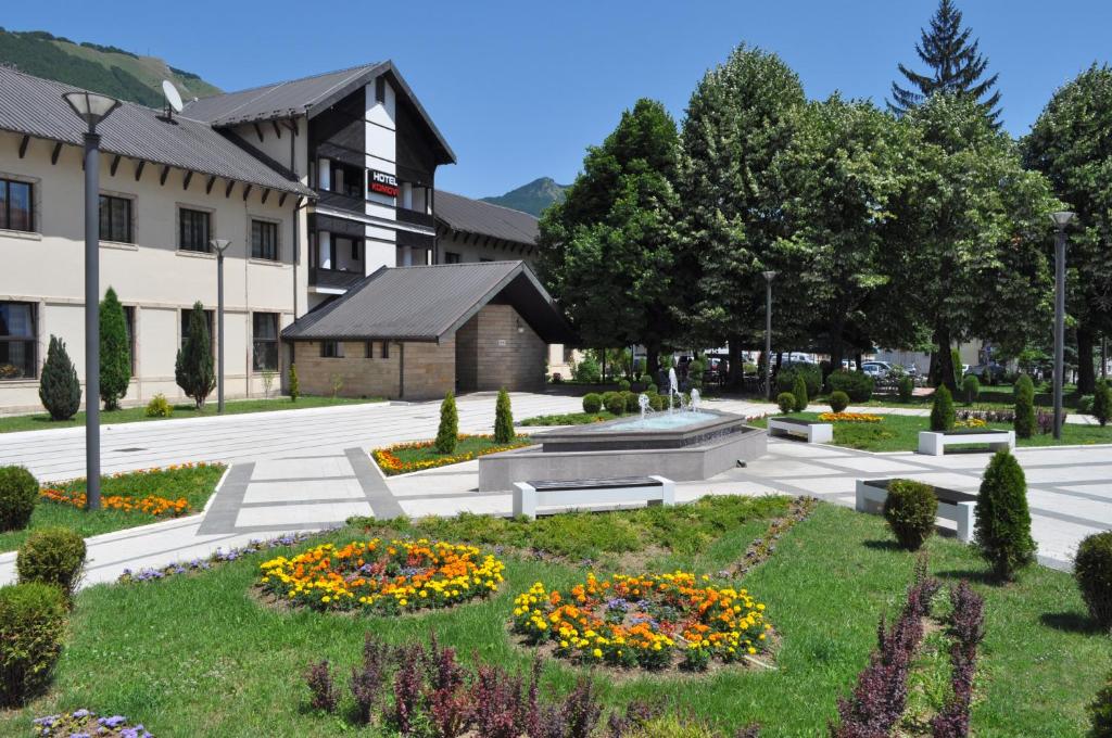 ein Park mit Blumen im Gras vor einem Gebäude in der Unterkunft Hotel Komovi in Andrijevica