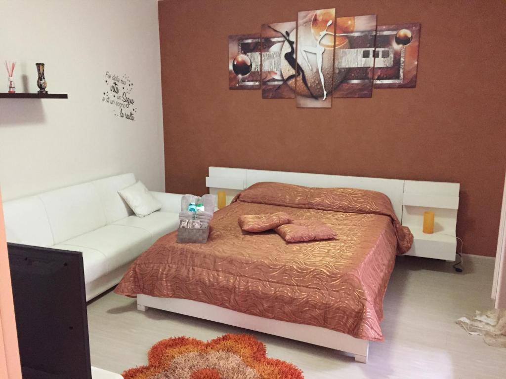 a bedroom with a bed and a white couch at Berenice in Taranto