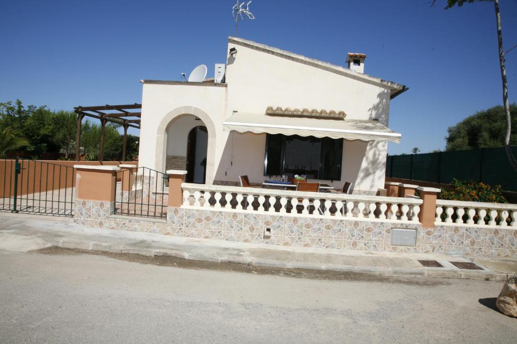 ein kleines weißes Gebäude mit einem Zaun. in der Unterkunft Lola in Sa Ràpita