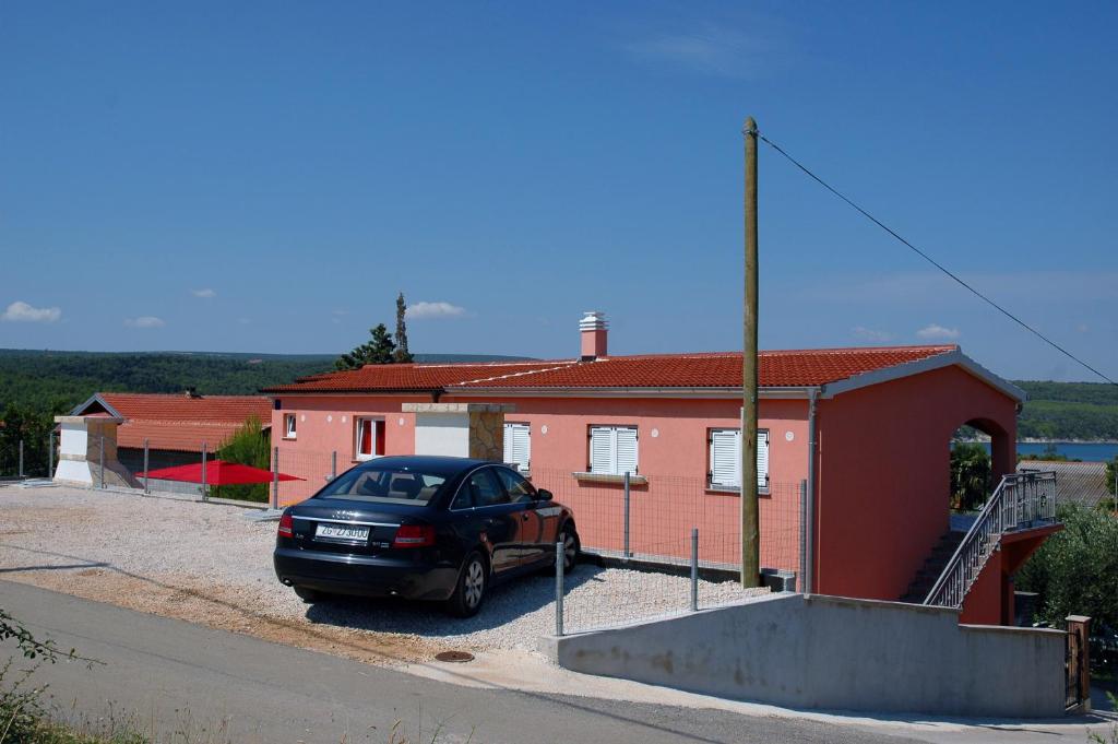 a black car parked in front of a house at Apartment Dora in Gornji Karin