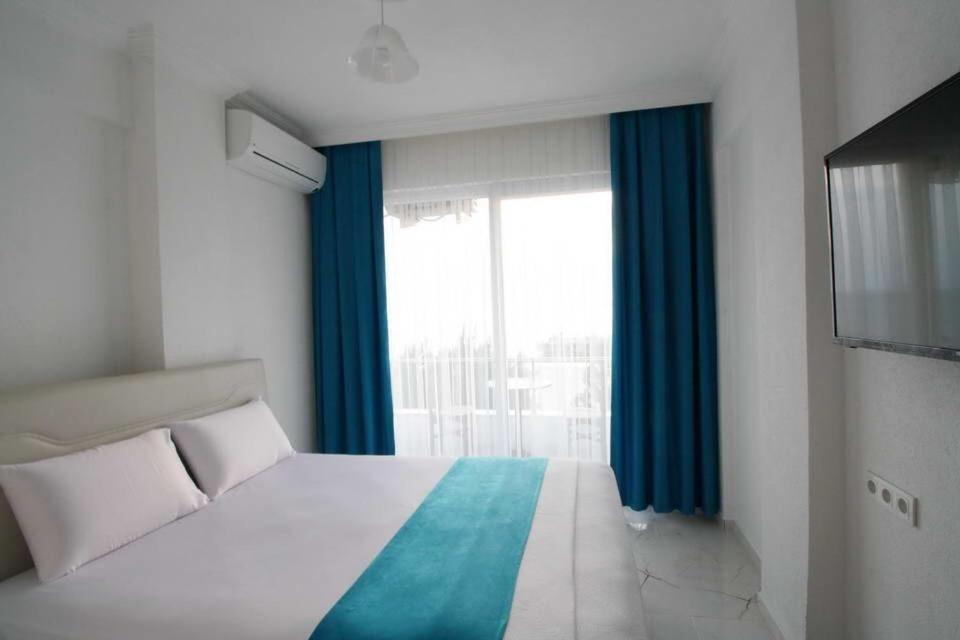 アーブシャ島にあるPegasus Prestijのベッドルーム1室(青いカーテン、窓付)