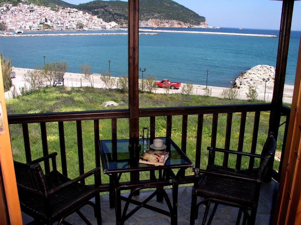 スコペロスにあるSpitalia Studiosのテーブルと椅子、海の景色を望むバルコニー